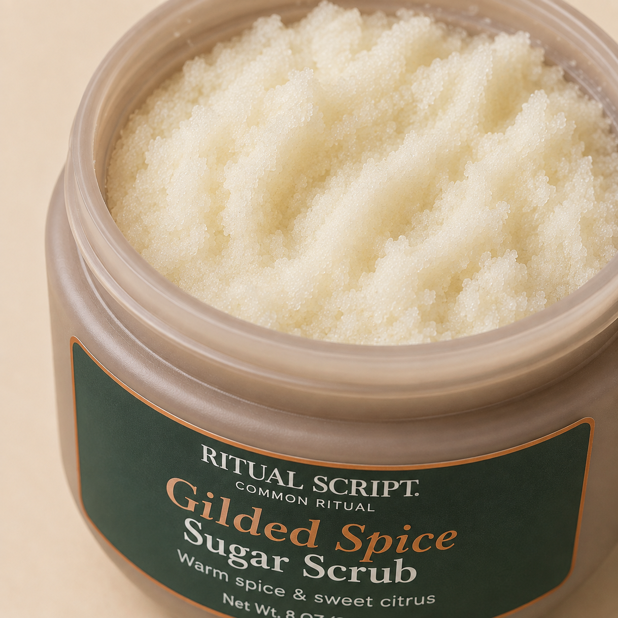 Open jar of Gilded Spice Sugar Body Scrub showing its thick pale sugar and shea butter texture