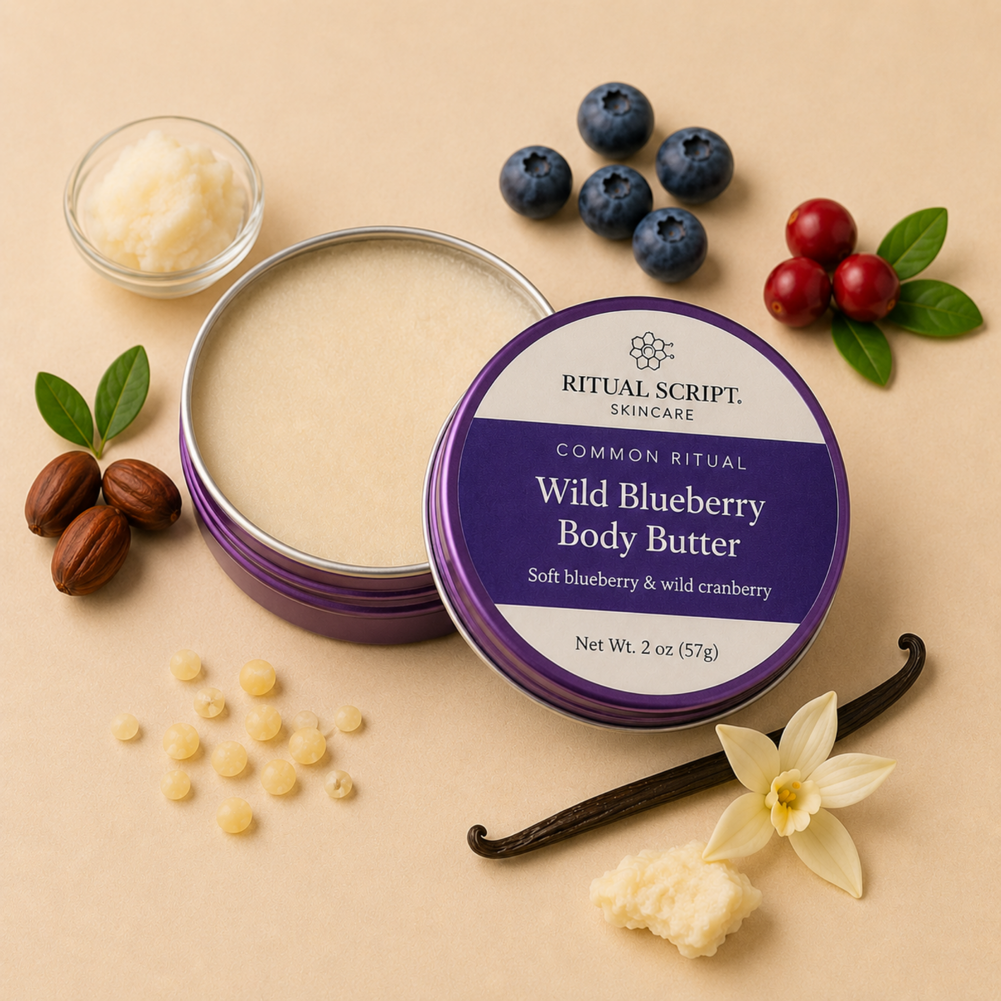 Open tin of Wild Blueberry Body Butter showing its soft ivory texture, styled with blueberries, cranberries, vanilla pods, and shea nuts